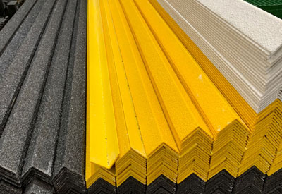 black, yellow and white anti-slip GRP nosing stacked on top of each other in stock