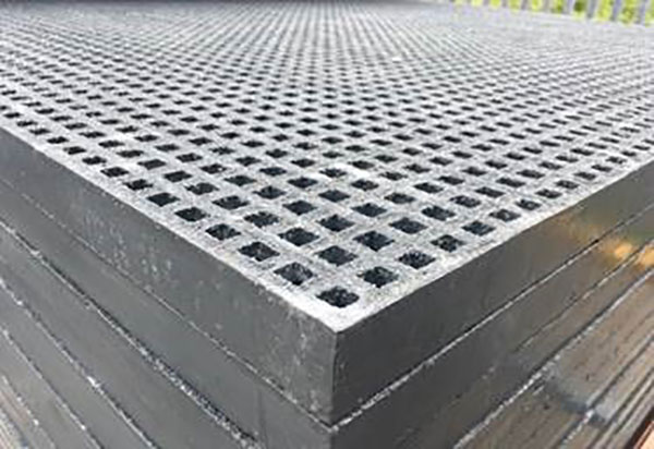dark grey mini mesh grp grating panels, fully bound, with a gritted surface stacked on top of each other