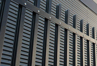 a black GRP fence against the side of a building